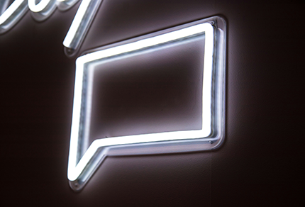A neon sign in the shape of a speech bubble.