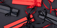 elegantly wrapped gifts with black and red paper and ribbons