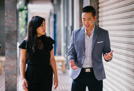 Two business people walking and talking outside.