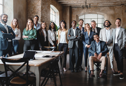 A diverse team of different ages, race, genders, and mixed-ability facing the camera.