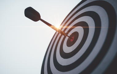 Dart hitting the bullseye of a target, with a bright spark at the point of impact.
