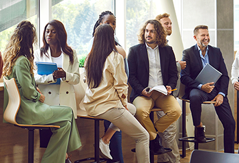 A group of diverse business professionals communicating at a conference, seminar or other event.