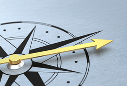 A stylized compass on a metallic background with a prominent yellow arrow pointing to the right, suggesting direction, guidance, or forward movement.