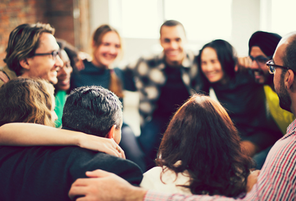 A team in a group huddle holding onto each other's shoulders.