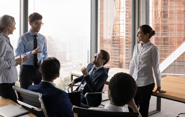 Team of professionals discussing ideas in a modern office meeting room.