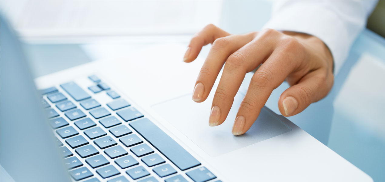 Close up of a hand using the trackpad on a laptop.